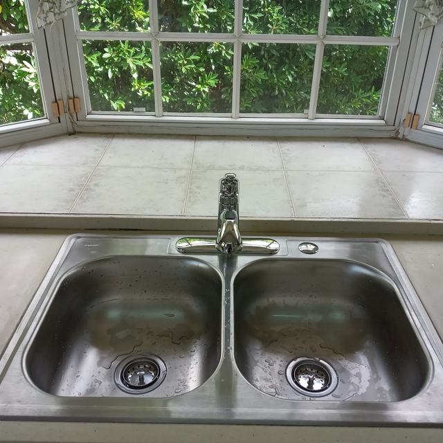 Double kitchen sink installed at a bay window